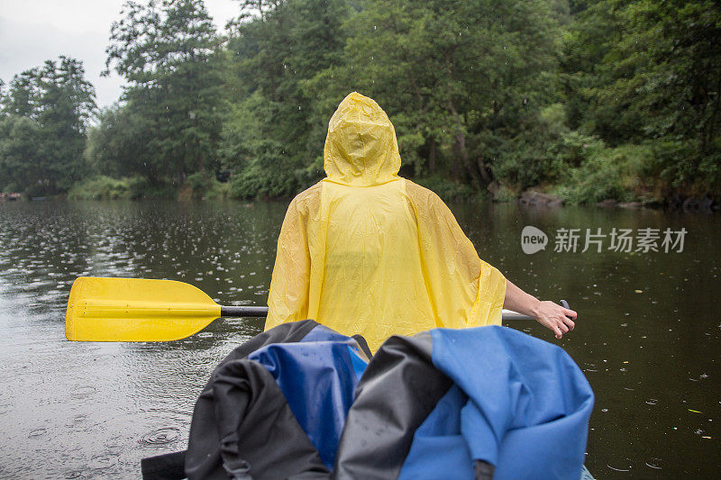 一个年轻女子在雨中划独木舟
