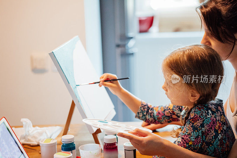 千禧妈妈和她的女儿在画布上画画