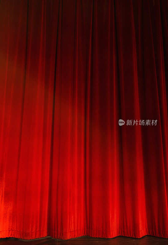 红色的舞台幕布，被脚灯照亮