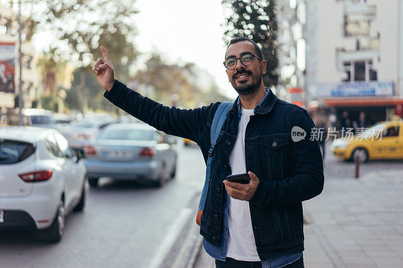 一名男子在城市街道上叫出租车