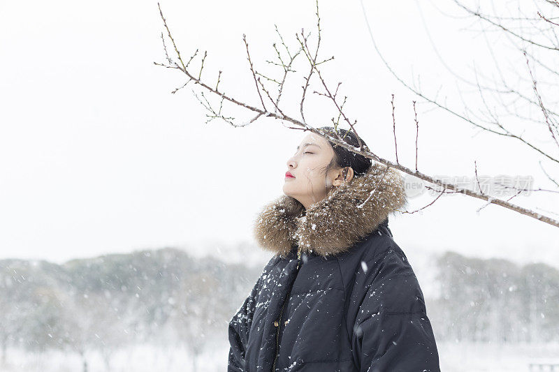 一个美丽的亚洲女人站在雪地里的肖像