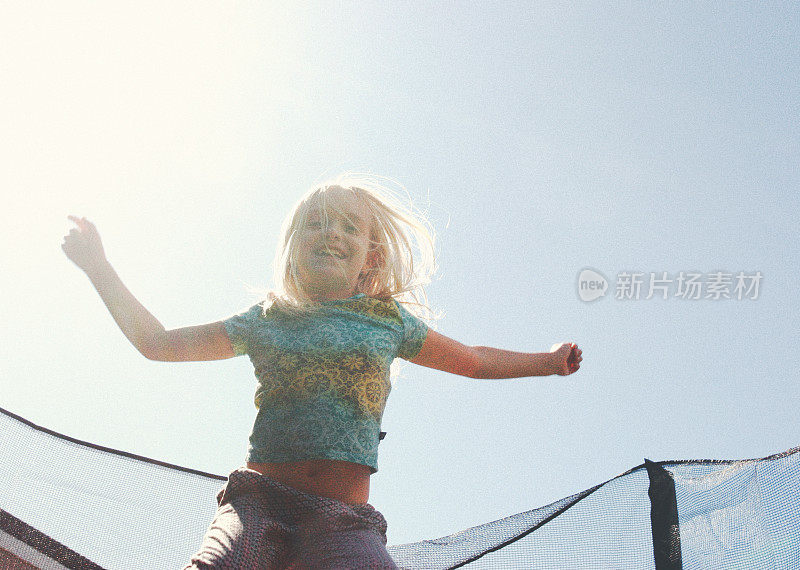 小女孩在蹦床上跳跃的模糊图像
