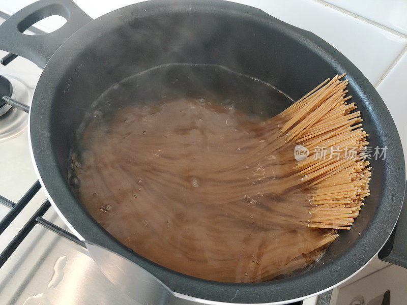 用热水平底锅盛着意大利面，供餐用