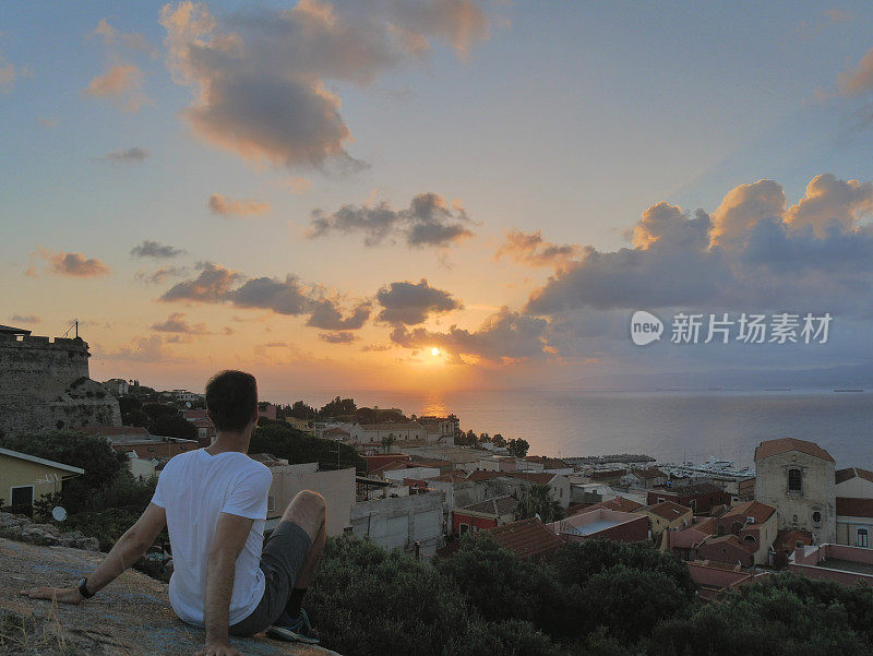 年轻人在海边小镇米拉佐和大海上看日出