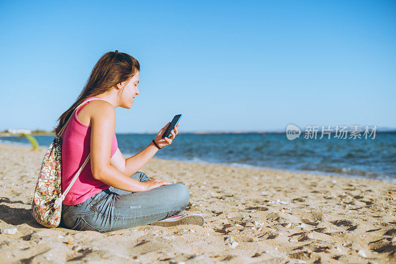 在海滩上用手机的女人