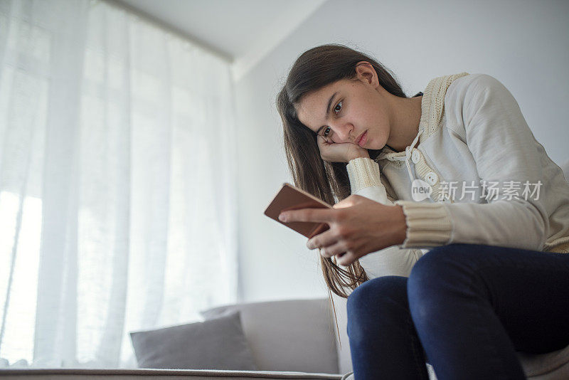 不开心的女孩拿着手机