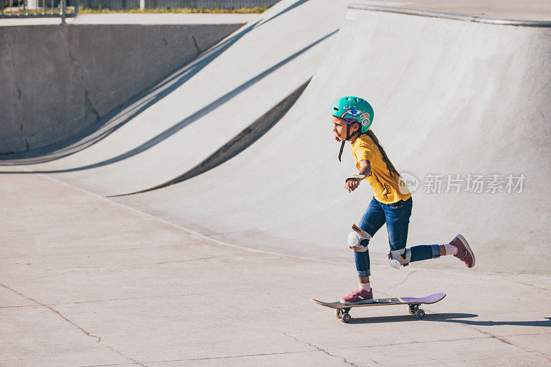 年轻的女孩滑板在滑板公园