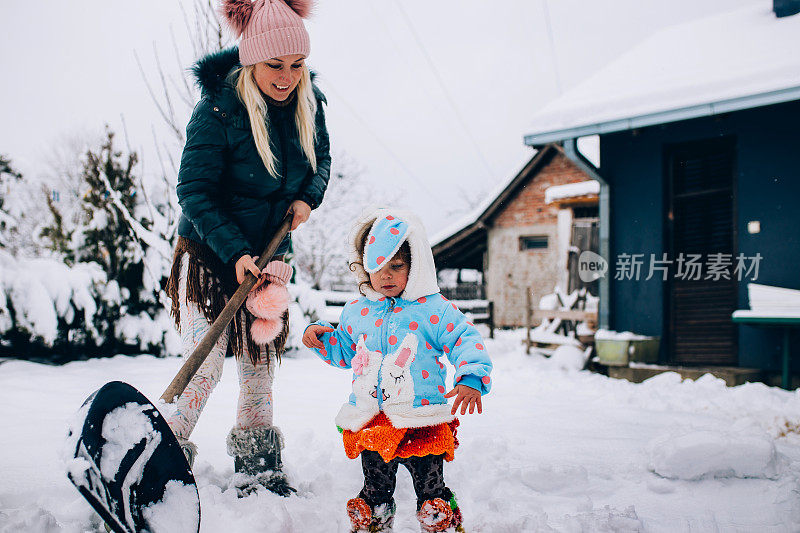 快乐的妈妈喜欢和她的孩子在雪地里玩