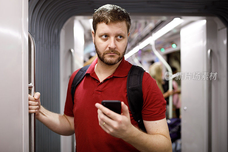 一名男子在地铁上用手机
