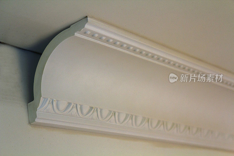 在室内装修改造中，用胶粘接在墙面和天花板上的装饰细部白色线条。