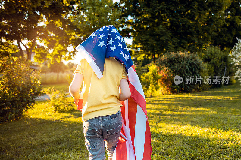 美国纪念或独立日的概念，一个男孩拿着美国国旗