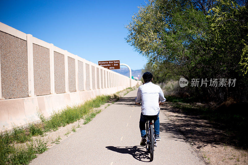 活跃的老年人在高速公路附近的自行车道上骑车