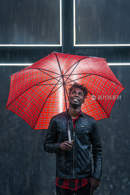 男人撑着红伞下着雨