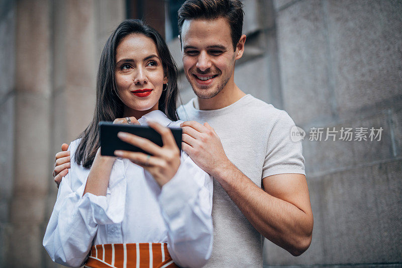 情侣在街上用智能手机