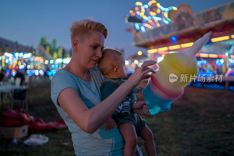 快乐的妈妈和宝宝在游乐园晚上的肖像
