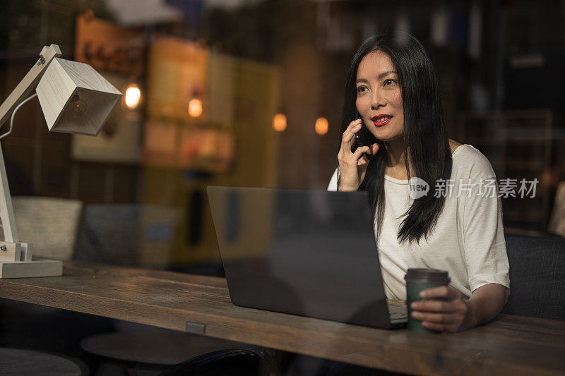 美丽的中国商务女性在咖啡店使用手机