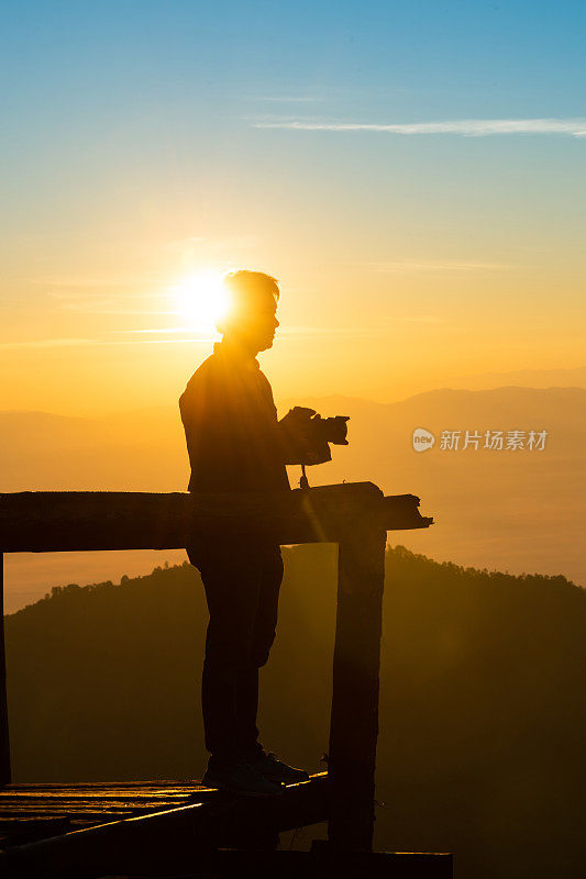 一名年轻人在泰国北部的吴康清迈自然景观日出景区用相机拍照