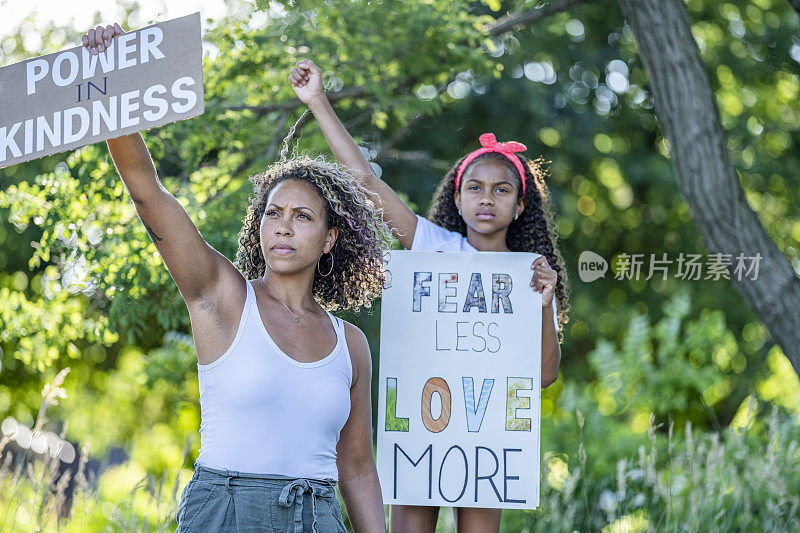 非裔美国人母亲和女儿举着抗议标语