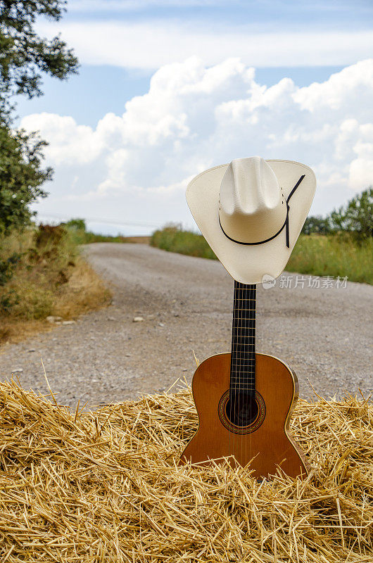 吉他，牛仔帽，干草和土路