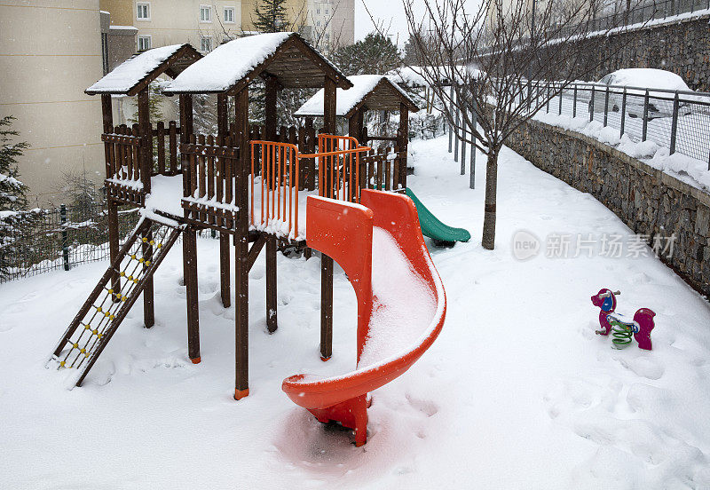 孩子的操场覆盖着雪和玩具在一个冬天的一天