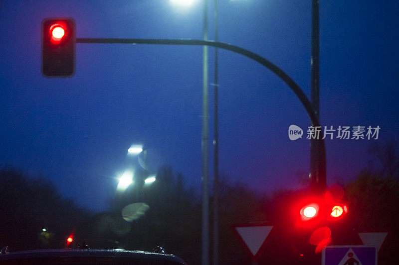 街景，红色交通灯，驾驶和城市生活在雨天。