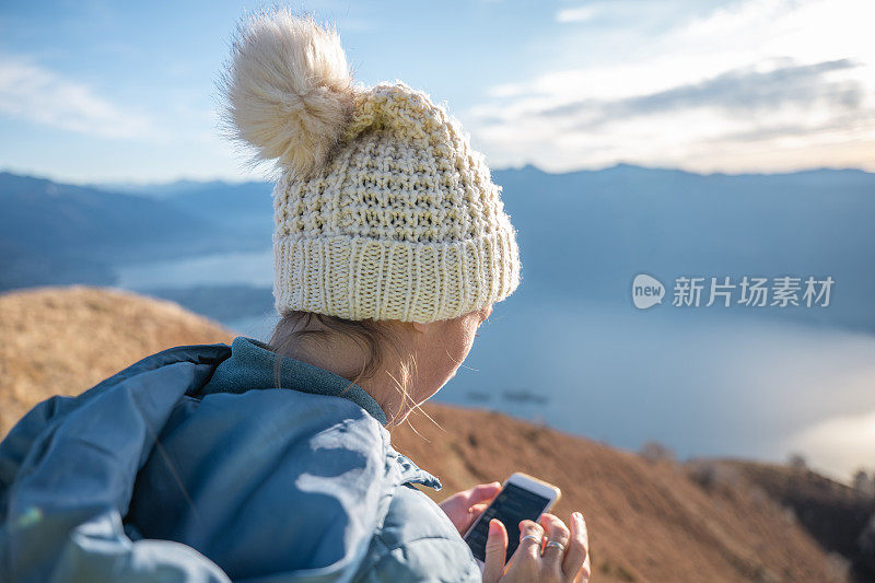 女徒步旅行者在山上使用手机