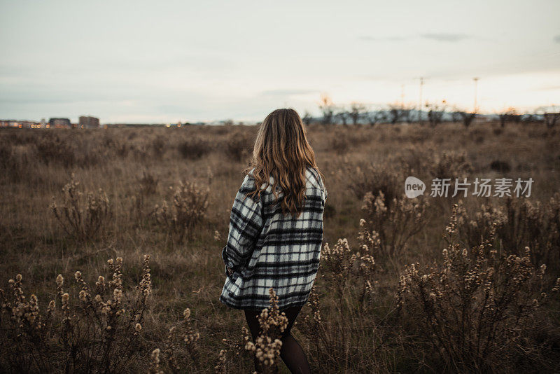 一个年轻女人在野外的后视图