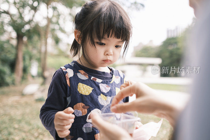 可爱的中国女孩在公园里吃糖果