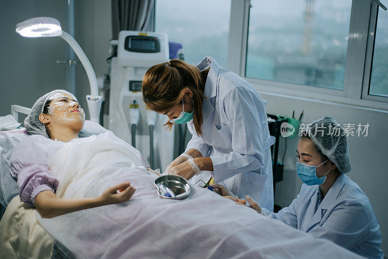 一名亚裔华裔女护士在诊所为一名中国女性患者的手臂静脉采血