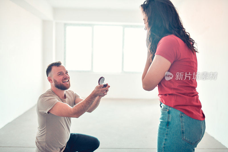 微笑的男人在新空公寓向女友求婚