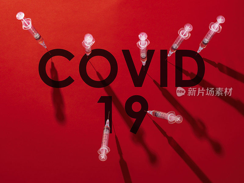 注射器上的针头刺入单词COVID-19的每个字母。