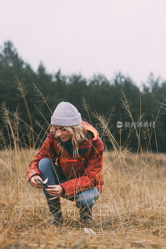 美丽的女性自然爱好者在下雨天采摘蘑菇