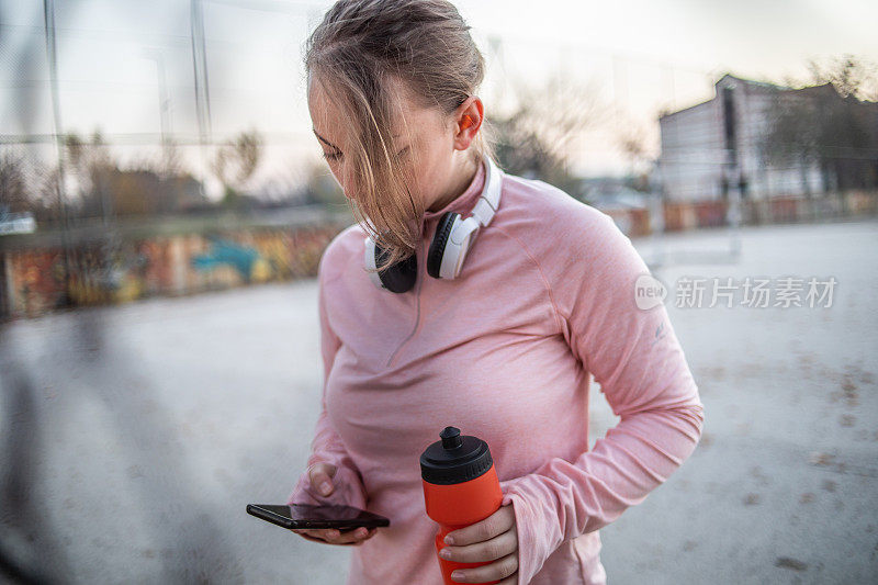 健身妇女在户外锻炼，做完训练正在休息。