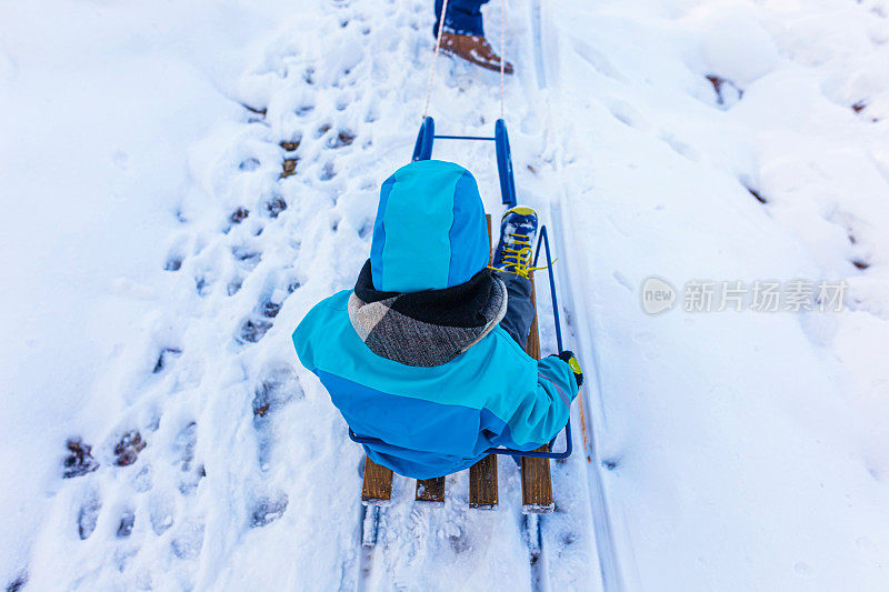 寒假里，蹒跚学步的机器人和家人一起玩雪橇