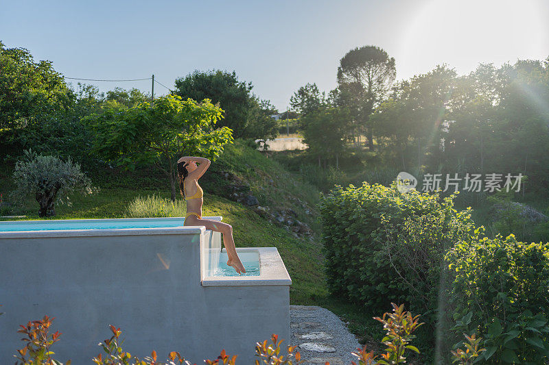 夏天，年轻女子在泳池边闲荡