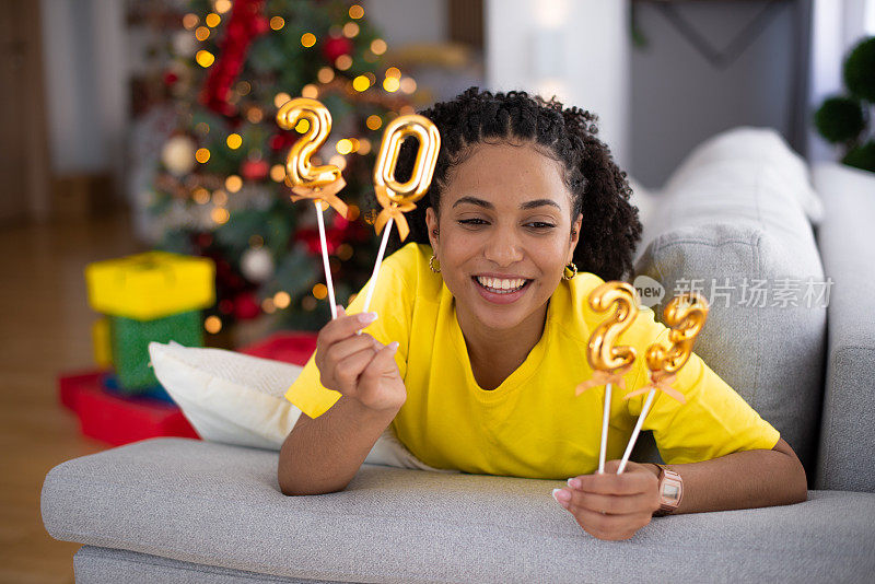 快乐的女人在家里庆祝新年库存照片