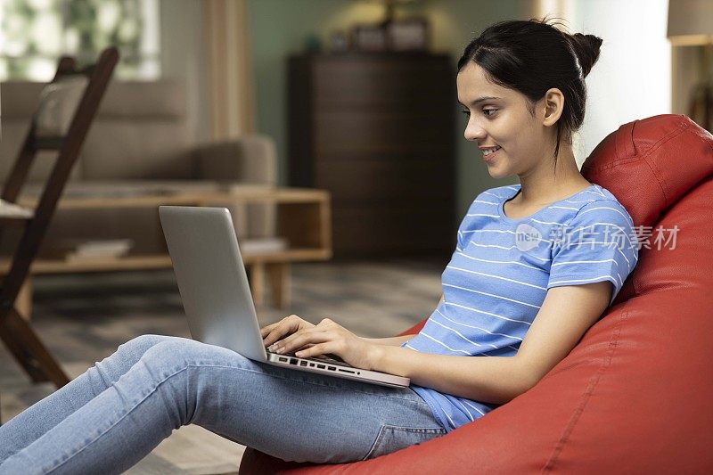 印度年轻女子使用笔记本电脑，库存照片