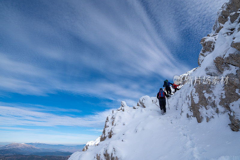 成功的登山队正在冬季攀登山顶