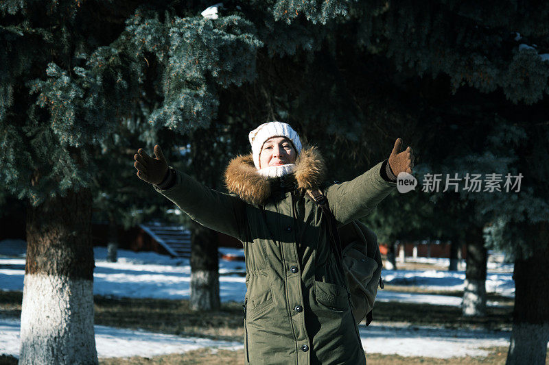 一个女人走在冬天小镇的大街上，带着幸福的微笑向别人打招呼