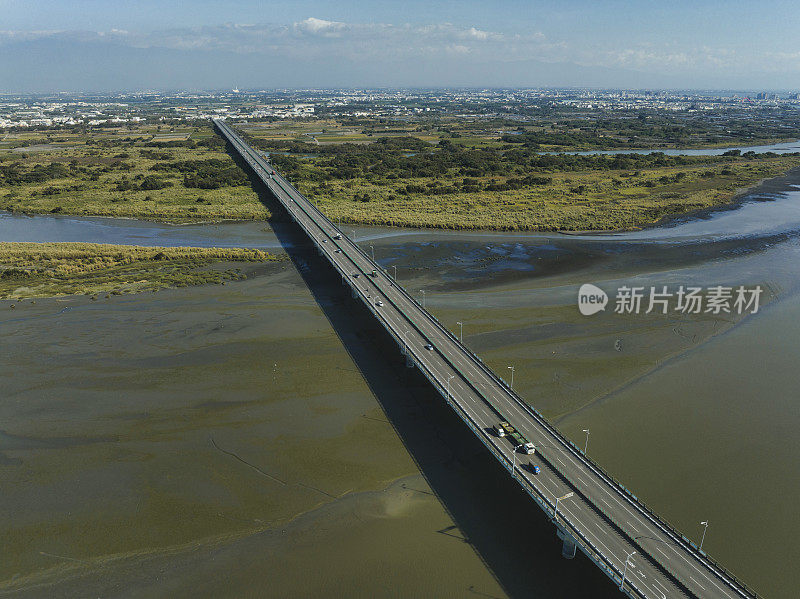 汽车在高速公路路口行驶的鸟瞰图。桥梁道路与绿色花园和树木相连接的建筑概念。