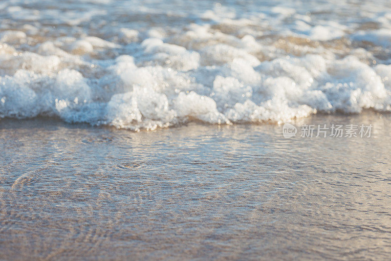 海浪涌向海滩，小浪拍打着沙滩。