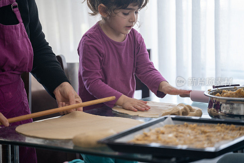 老祖母和孙女在厨房准备糕点的照片