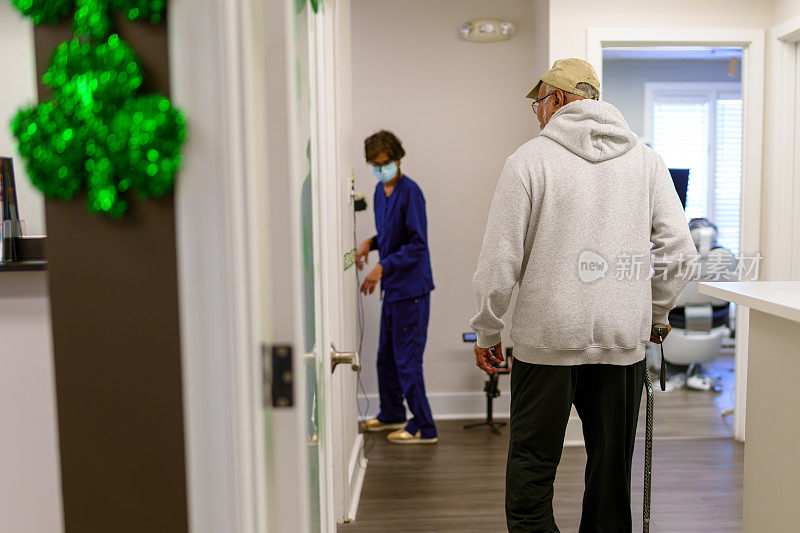 老年男性病人走向牙科诊所的检查室