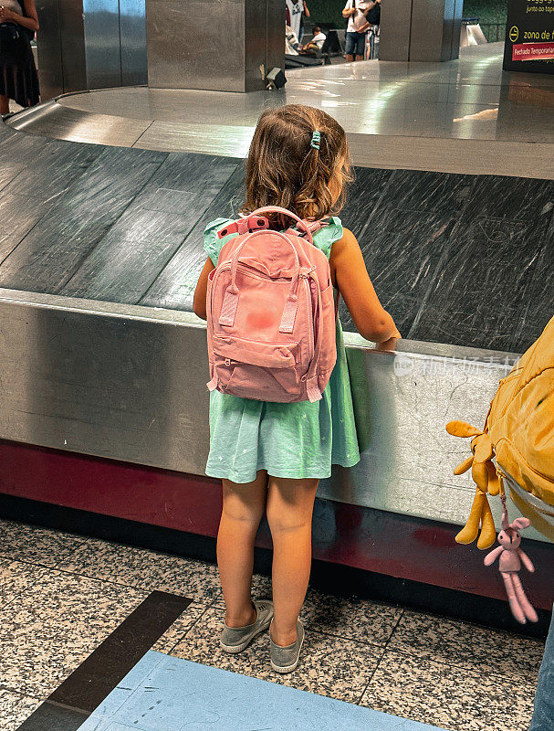小女孩在葡萄牙机场等行李