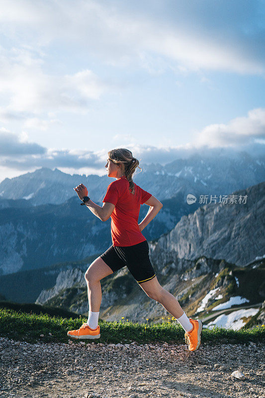 女越野跑运动员沿着山路跳跃