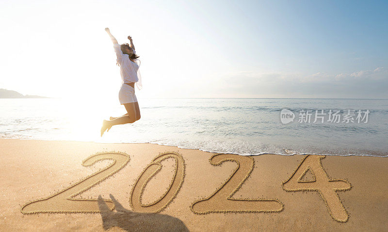 女子在新年第2024年的海滩上跳跃