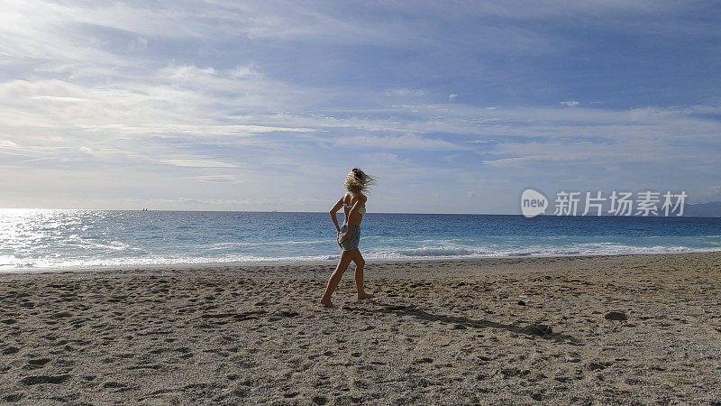 年轻女子沿着沙滩散步
