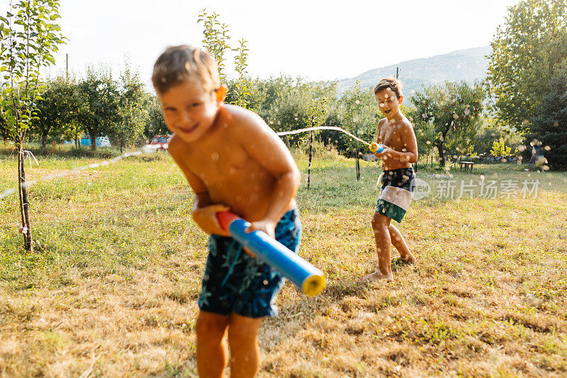 炎热的夏日，孩子们在院子里打水仗