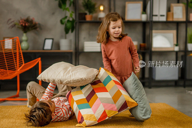 孩子们在家里的地板上玩枕头，打枕头仗