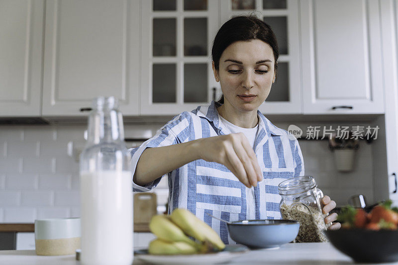 女人在厨房享用早餐。准备健康早餐。